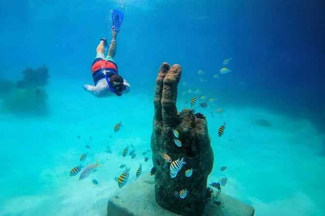 Luxury catamaran sailing to Isla Mujeres with snorkelers in the turquoise Caribbean water on a Cancun snorkeling tour